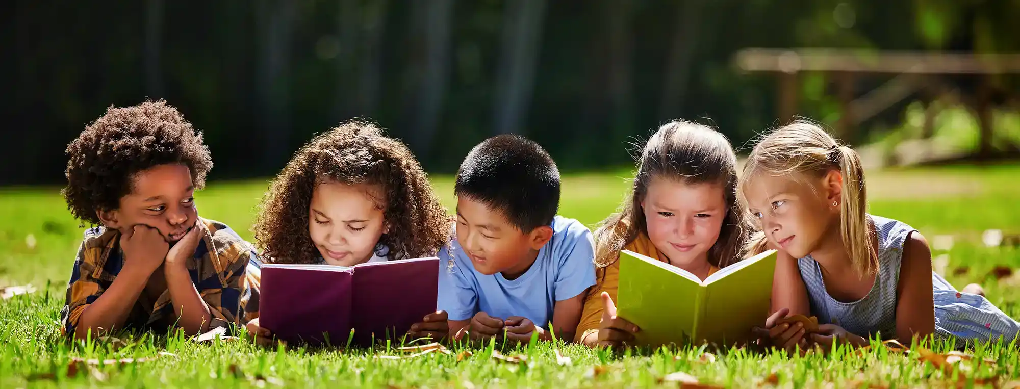 Kids reading on a lawn
